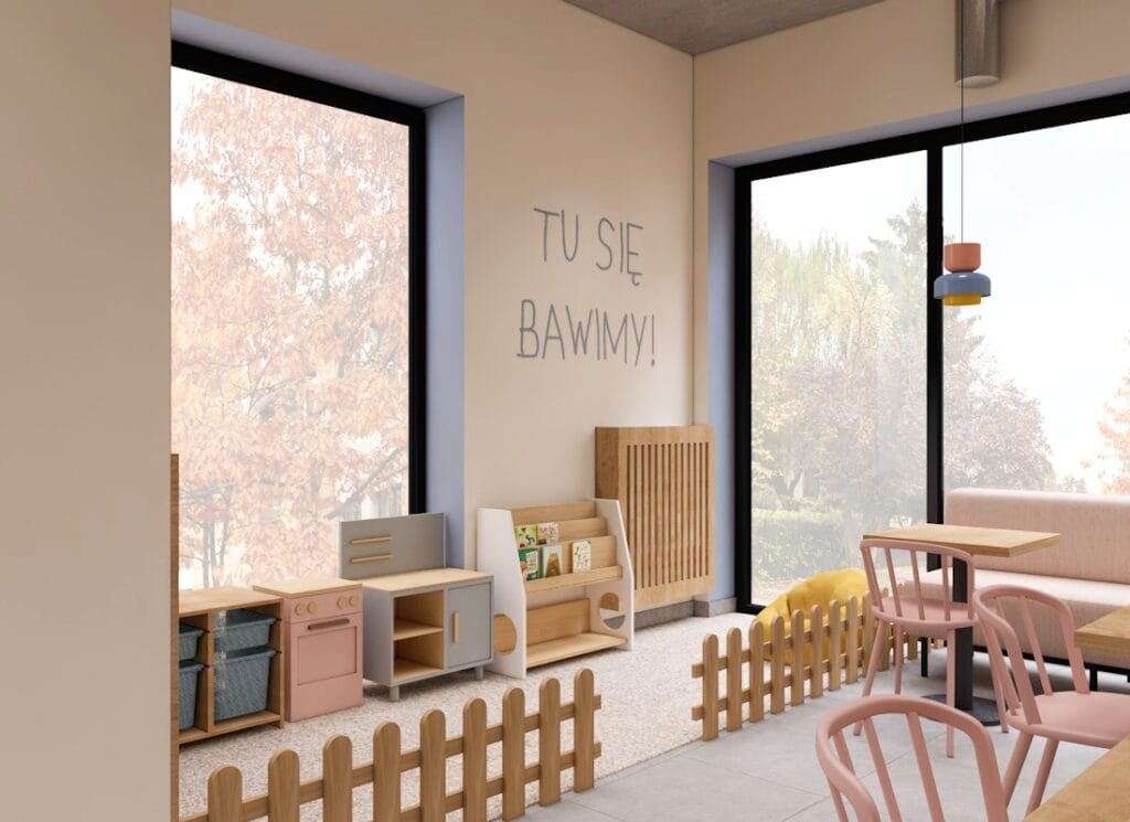 Kącik dla dzieci w kawiarni, wyposażony w drewniane meble i zabawki.