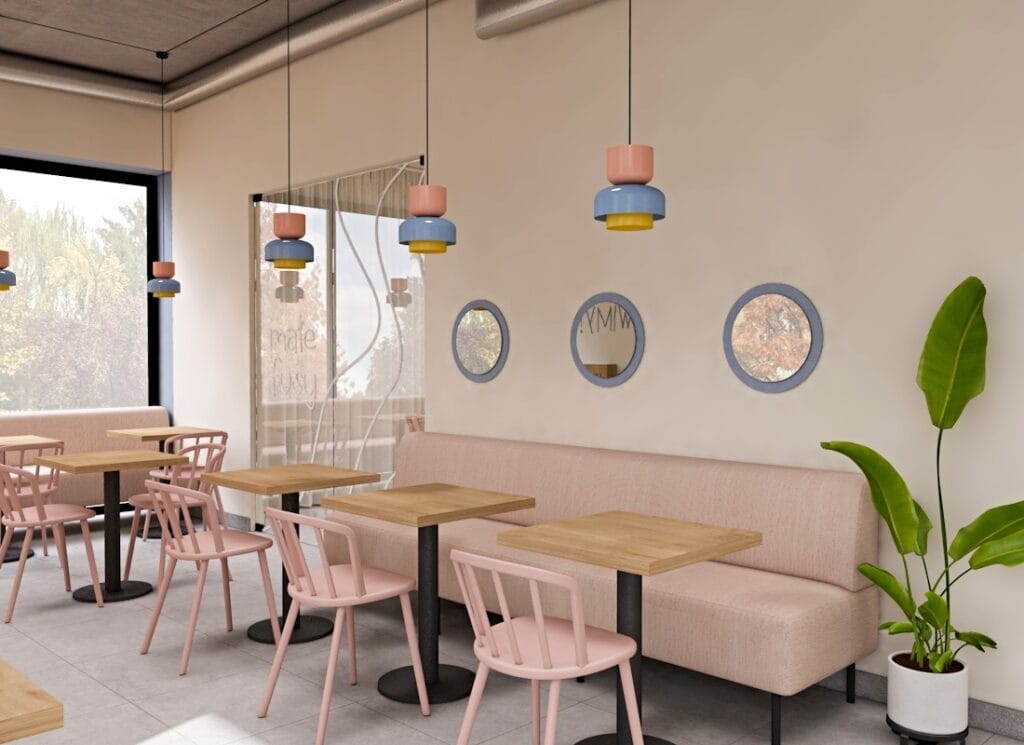 Nowoczesne wnętrze kawiarni z pastelowymi lampami wiszącymi nad drewnianymi stolikami i różowymi krzesłami.