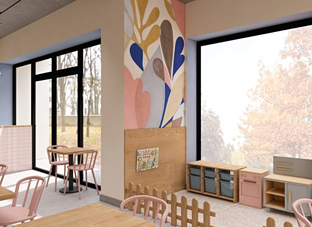 Industrialne wnętrze kawiarni z dużymi oknami, surowym betonowym sufitem i pastelowymi akcentami.